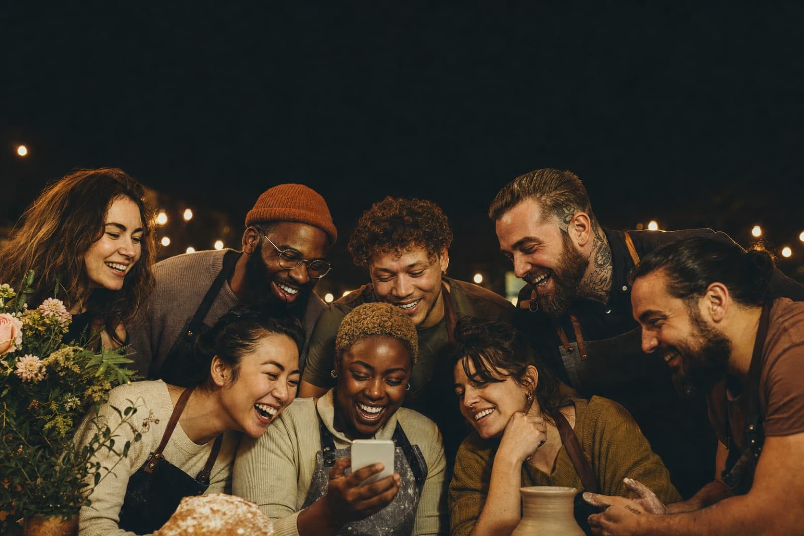 Creators and small business owners celebrating their growth around one phone